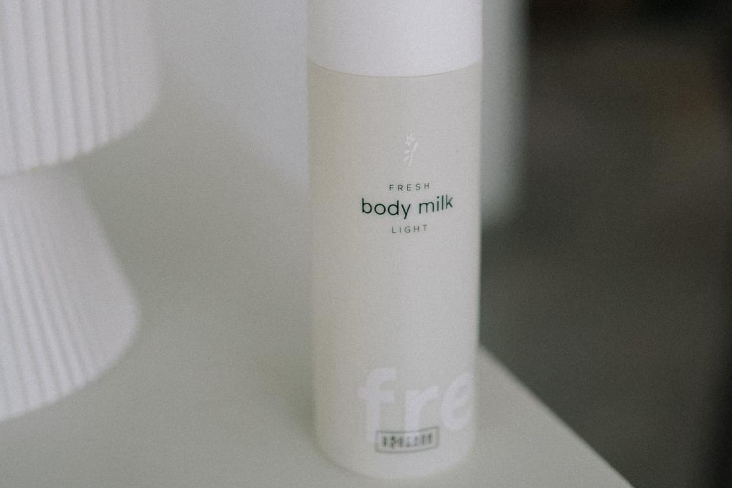 RINGANA FRESH body milk light allein auf einem weissen Podest