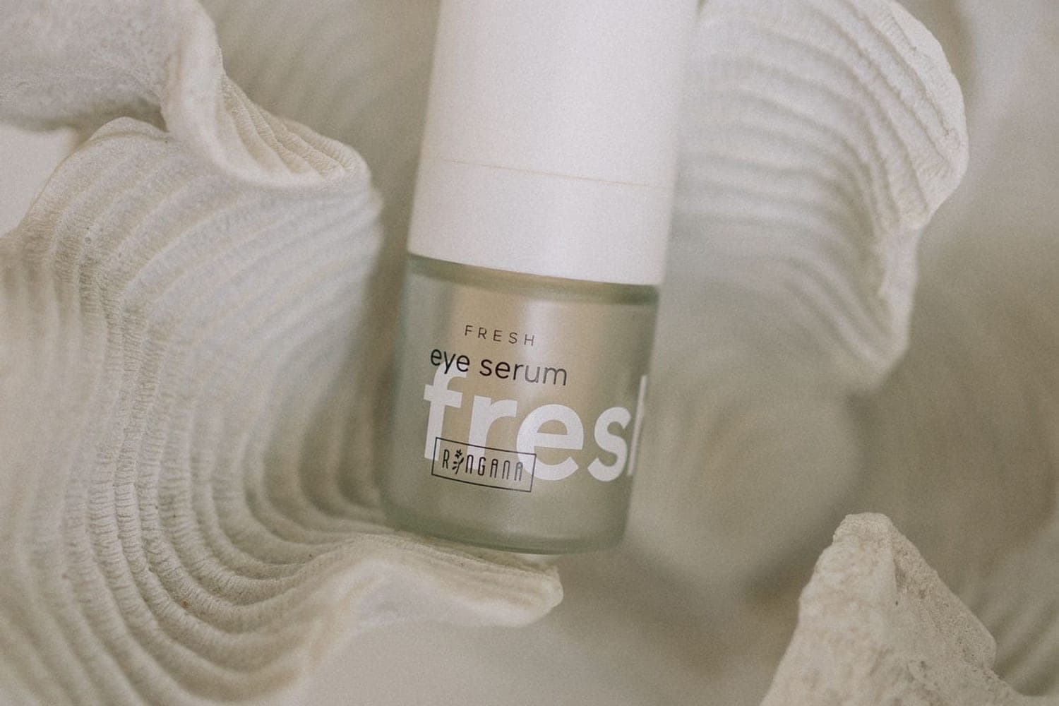 RINGANA FRESH eye serum auf einer hellen Korallenstruktur