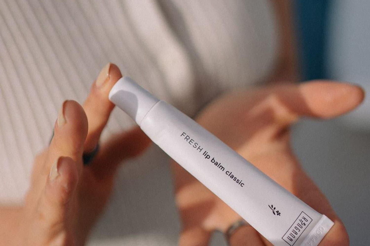 RINGANA FRESH lip balm classic auf einer offenen Handflaeche